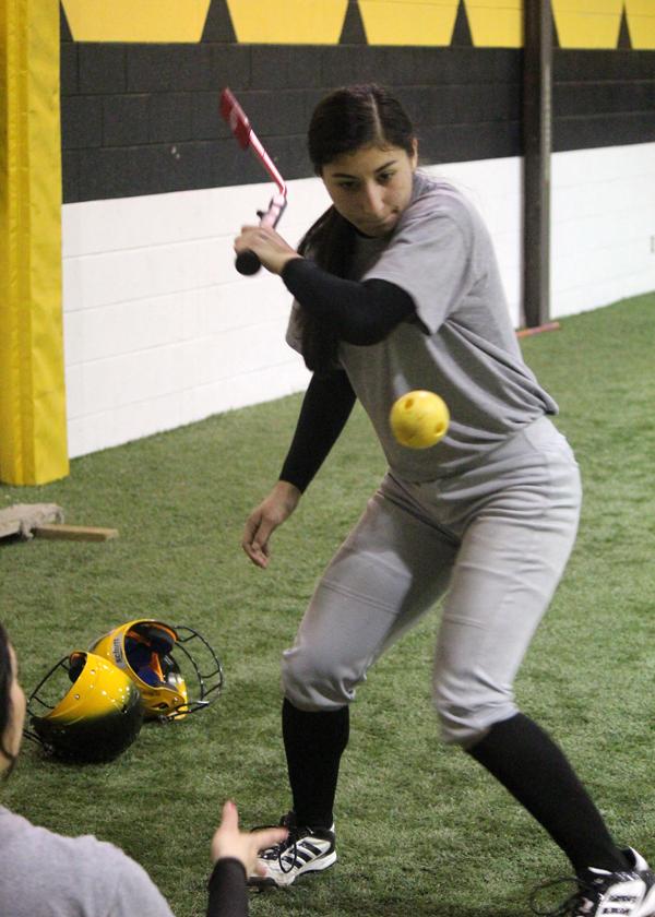 Hand to eye--
Sophomore pitcher Melanie Sendejo swings at the ball as a teammate pitches it during workout Feb. 5