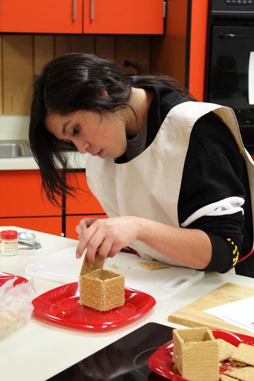 Seasonal structure--
Senior Stefany Moriel puts pieces of her gingerbread house together using Royal icing in seventh period lifetime nutrition and wellness on Dec. 3.
The class completed the houses Dec. 5.