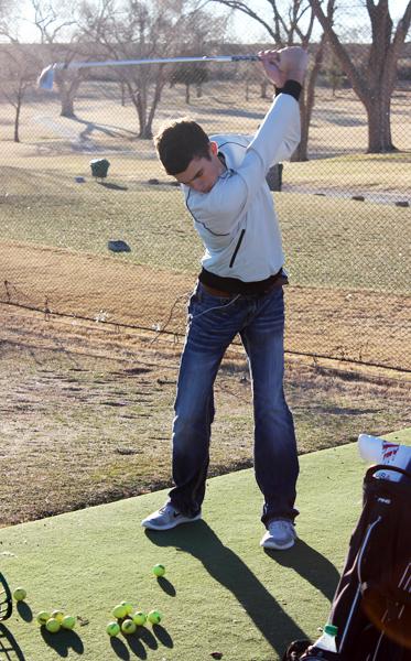 Practice makes perfect--
Senior Branson Moore drives a pile of golf balls during practice on Jan. 27.