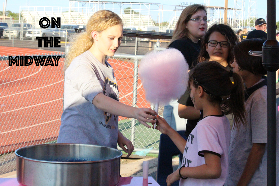 Carnival candy--
Senior Brooke Langham gives cotton candy she just made to a customer on the Wigwam Midway on Sept. 15. The booth was sponsored by the library.