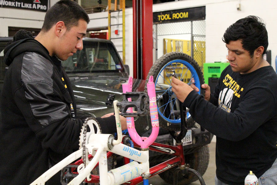 Making Christmas--
SkilsUSA junior Jesus Martinez Vizcarra and senior Geovanny Arroyo work on refurbishing a bicycle during eighth period auto tech class. The chapter hopes to give 40 families Christmas in conjunction with the Give a Child a Smile program.