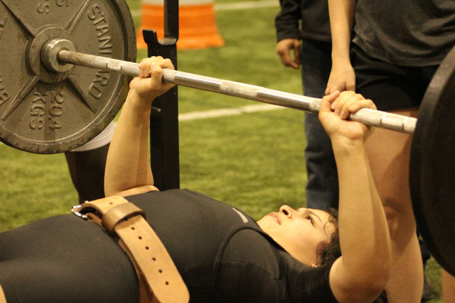 State bound--Sophomore Siria Martinez bench presses during the home meet on Feb. 1. Martinez lifted a combined 785 pounds in the 181-pound category to qualify for state on March 3.