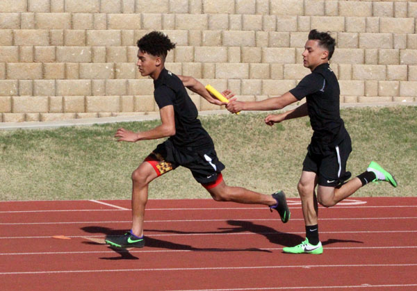 Hand off--Freshman Sergio Soto gives the baton to the second leg, freshman Makii Bates, during the 800-meter relay at the district meet on April 7. The team, which included junior James Hurston and freshman Damion Espino, qualified for area in fourth place.