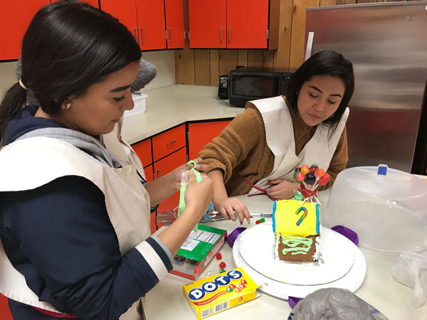 Sweet competition--
Sophomore Alyssa Parra and junior Laura Morales Andrade work on their gingerbread competition house during first period culinary.