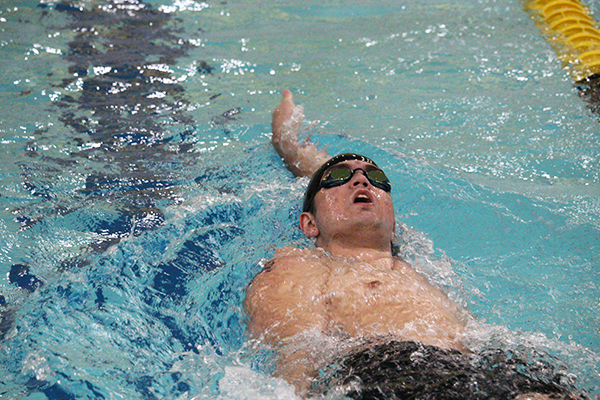 REACHING FOR SPEED--Senior Andy Proffer takes second in the mens 100-meter backstroke at the double dual meet on Oct. 8. Proffer also won the 100-meter breaststroke and swam in the relays.