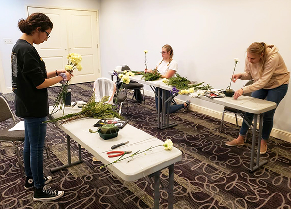 Getting certified--
Junior Kylie Lopez, junior Penelopi Neudorf and senior Elisabeth Hiebert Wiebe work on the level one floral certification hands-on test in October.