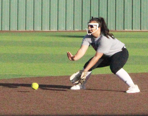 Scooping it up--
Glove extended, junior pitcher Alyssa Olivas fields a ball during practice on Feb. 10 during after school practice.
