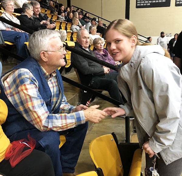Thanking their service--SkillsUSA Culinary senior Katy Beth Lashaway shows veteran Darrell Johnson to his seat at a home basketball game. The SkillsUSA chapter honored five veterans during January and February home games.