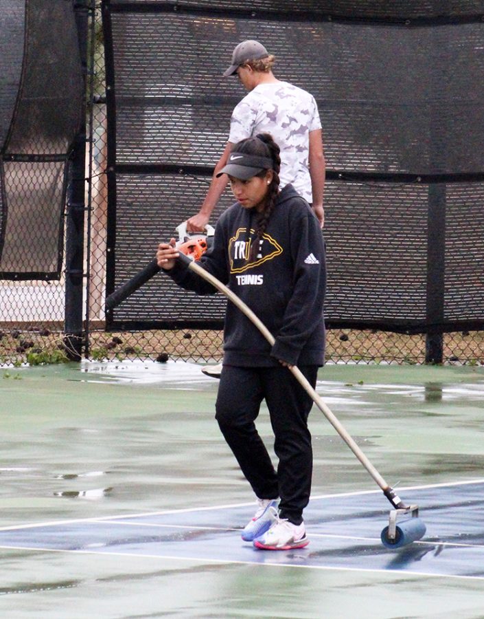 Making it safe--Senior Paulina Morales Mendoza goes over the courts with a squeegee before district play on April 16. Rain moved play several times, but Morales Mendoza would eventually take the championship in womens singles.