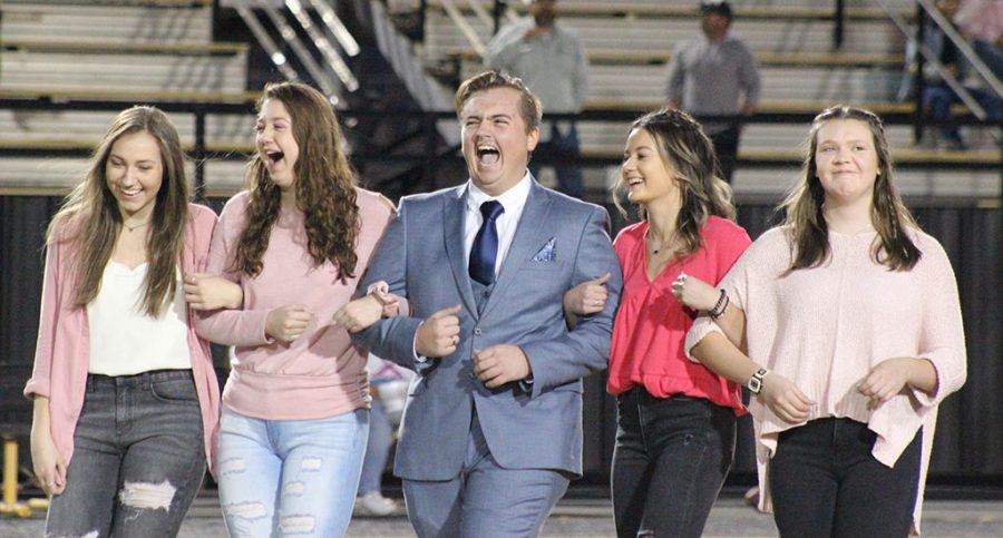 Entourage--Senior Jimmy Dyck bursts into laughter at the jokes made by the announcer during the powder puff king coronation on Oc.t 14. He was escorted by seniors Jasmin Guenther, his friend Eva, senior Sydney Loewen and senior Amber Schmitt.