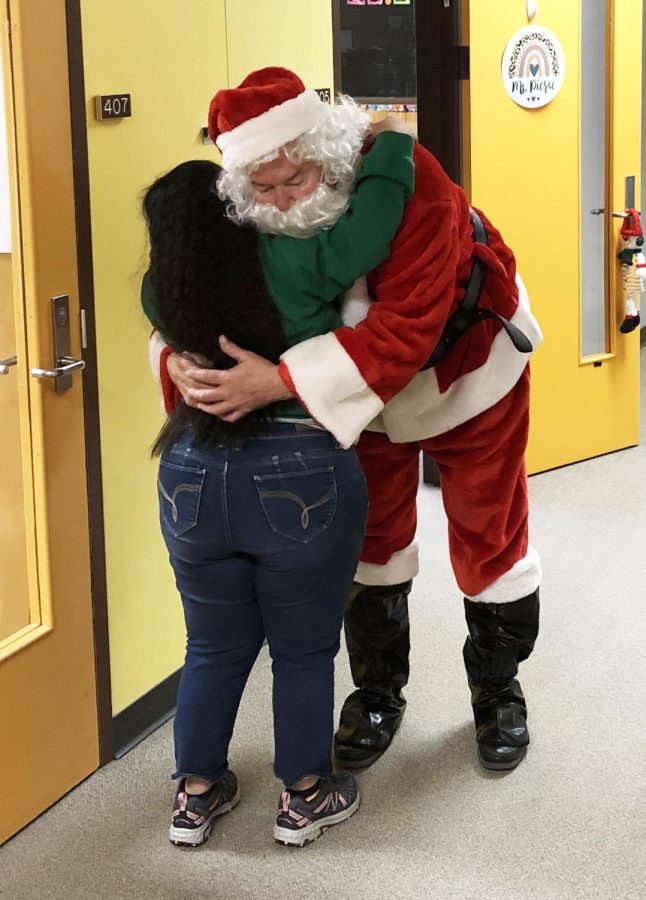 Greetings from Santa--Senior Maria Wilkins gives Santa Claus, aka Principal Robert Chappell, a hug as he was out patrolling the halls on Dec. 1.