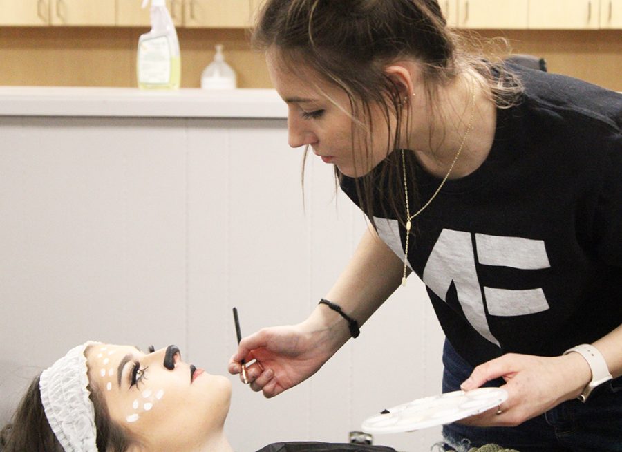 Transformation project--SkillsUSA Cosmetology senior Jazmin Guenther decorates senior model Aidyn Tonys face while practicing for the esthetics competition on Feb. 23. Guenther would take first place in district to advance to state.