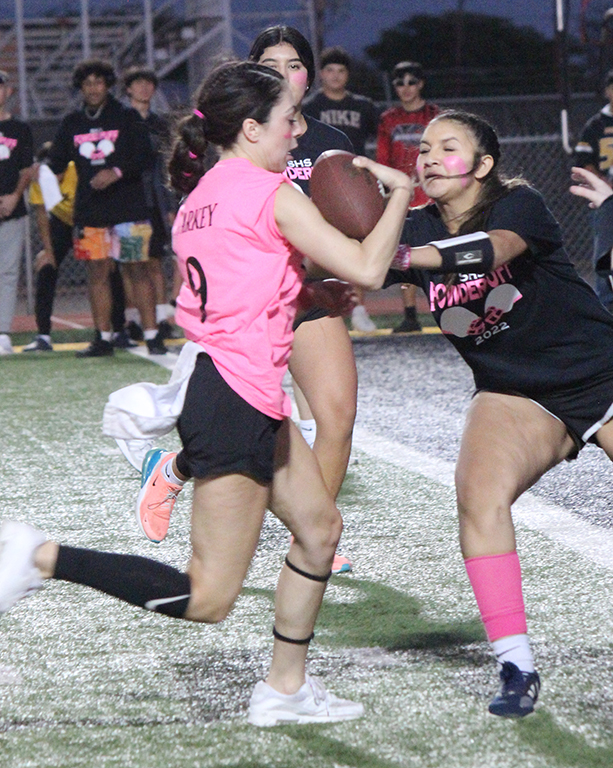 Into coverage--Senior quarterback Isabella Parkey runs into the underclassman defense as freshman Valerie Reyes tries to take her flag.