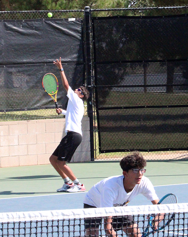 Teamwork--
Senior Brayden Baumgartner serves the ball over his partner, sophomore Tristan Hare, as they play men’s doubles versus Levelland on Sept. 9. The duo defeated the Lobo team of Trevino/Quintanilla, 6-0, 6-0.