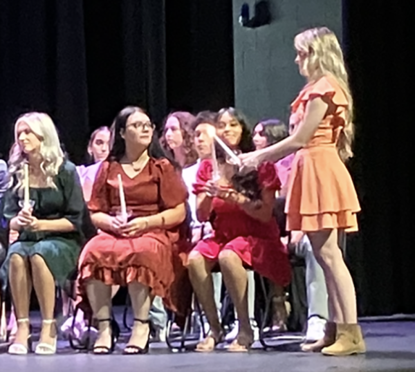 Light of knowledge--Senior NHS Historian Peyton Casey lights new members' candles during induction on August 28.