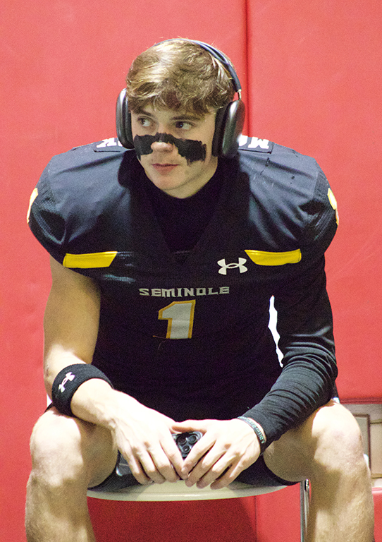 Gathering his thoughts--Junior wide receiver Logan McCormick sits listening to music in the locker room in Denver City before the bi-district game on Nov. 15. McCormick two receiving touchdowns in the Indian win.