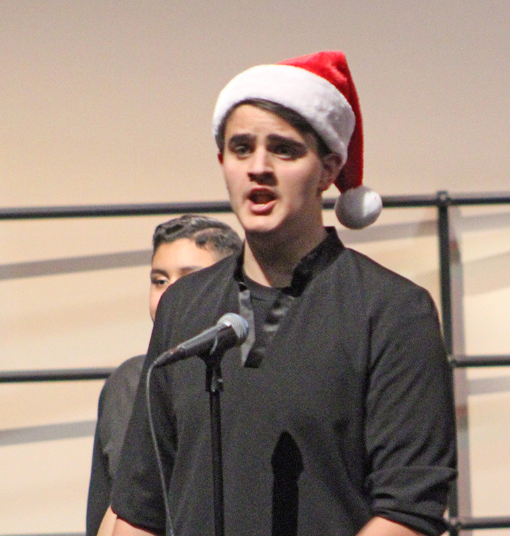 At the mic--Sophomore Timothy Holt utilizes his bass voice during a solo in"You're a Mean One, Mr. Grinch" during the choir's concert on Dec. 16. Holt followed in his older brother's footsteps to be a member of the show choir.