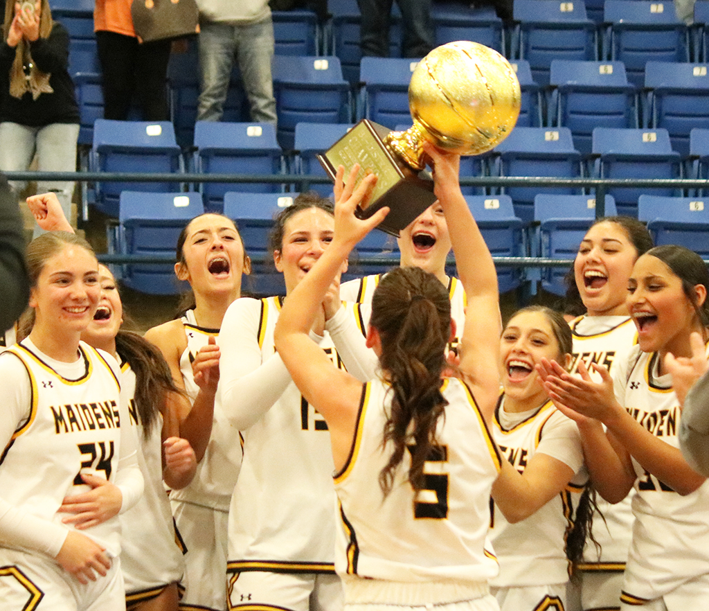 First round joy--The Maiden basketball team celebrates after receiving the bi-district trophy in Wolfforth on Feb. 10. The Maidens defeated West Plains, 63-39.