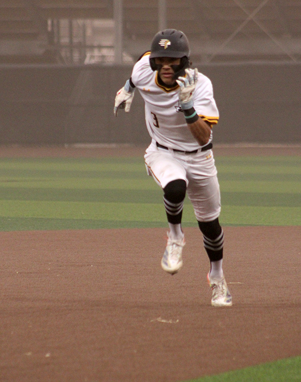 Into the wind--Freshman center fielder Jaycen Robredo fights to run to third into gale force wind from the west on March 18. The wind and dust wreaked havoc with play.