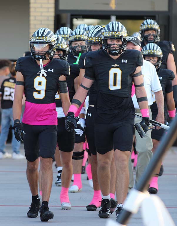 Pinked out ready--Indian football players leave the locker room on Oct. 10 decked out in pink accents.