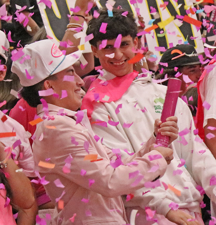 Confetti cloud--Juniors Omar Pinon and C.J. Mendoza join the pink flurry during the battle cry on October. 10.