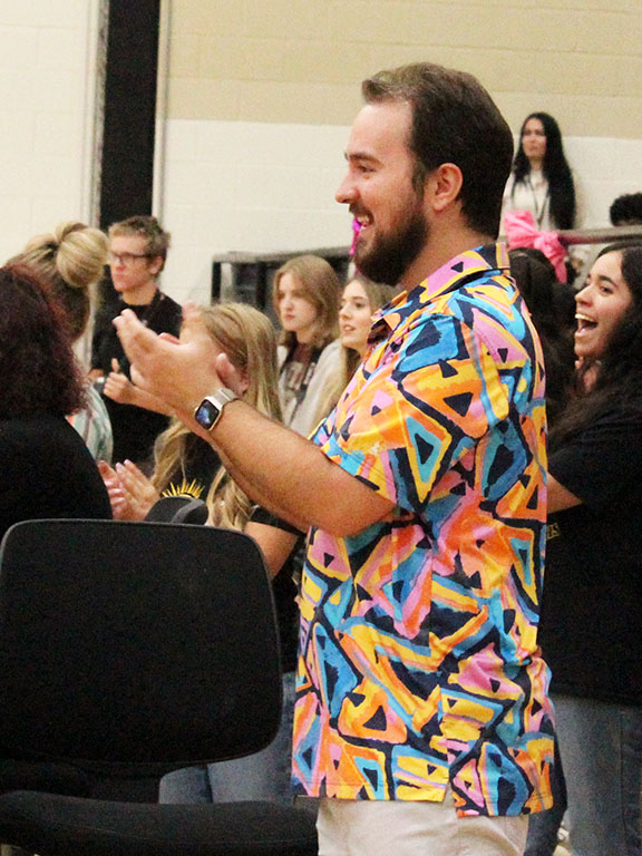 Proud approval--Seminole High School color guard Director Aaron Meyers claps after his guard members perform a difficult toss stunt during the powder puff pep rally on Oct. 6. 
